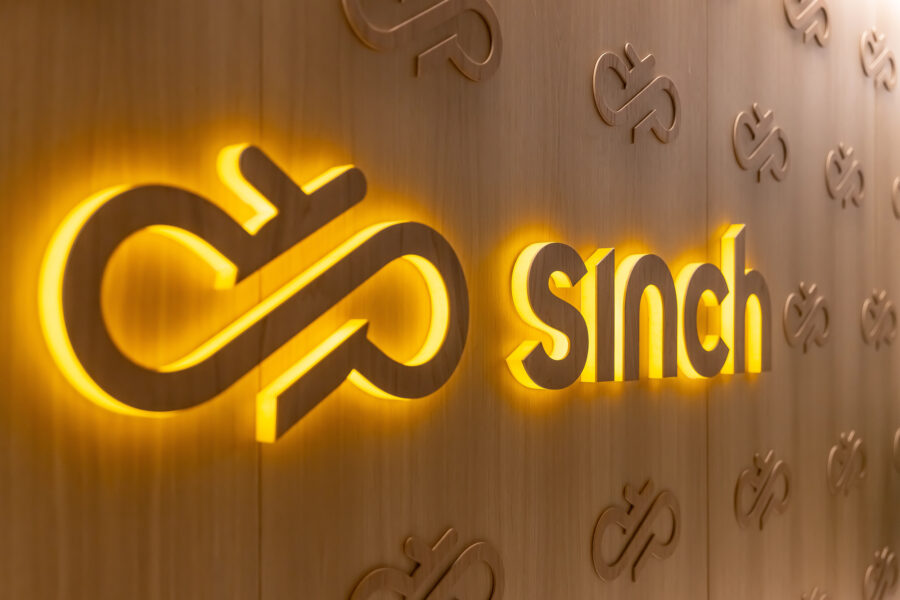 Sinch logo in neon on a wood-panelled office wall
